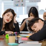 tired exhausted businesspeople sleeping after working late overtime